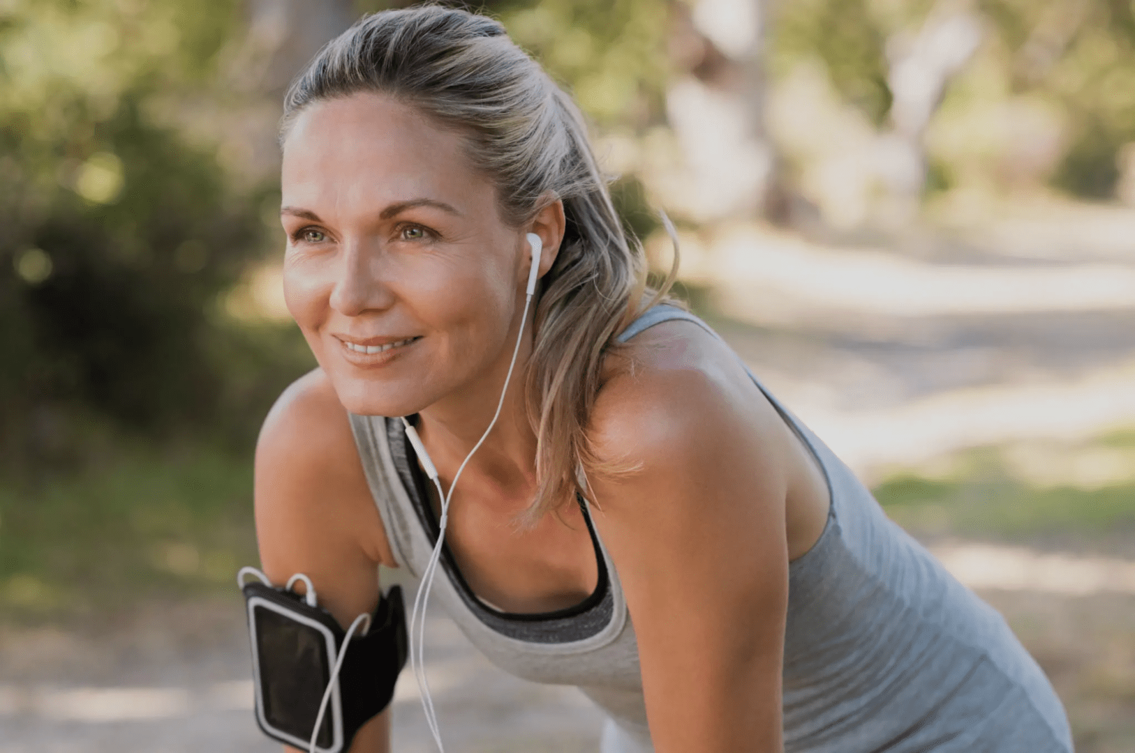 A woman with headphones on and smiling.