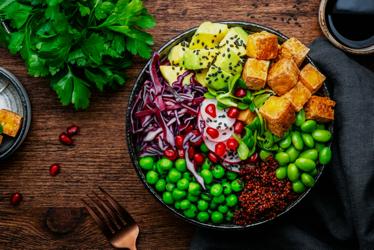 A bowl of food with vegetables and tofu.