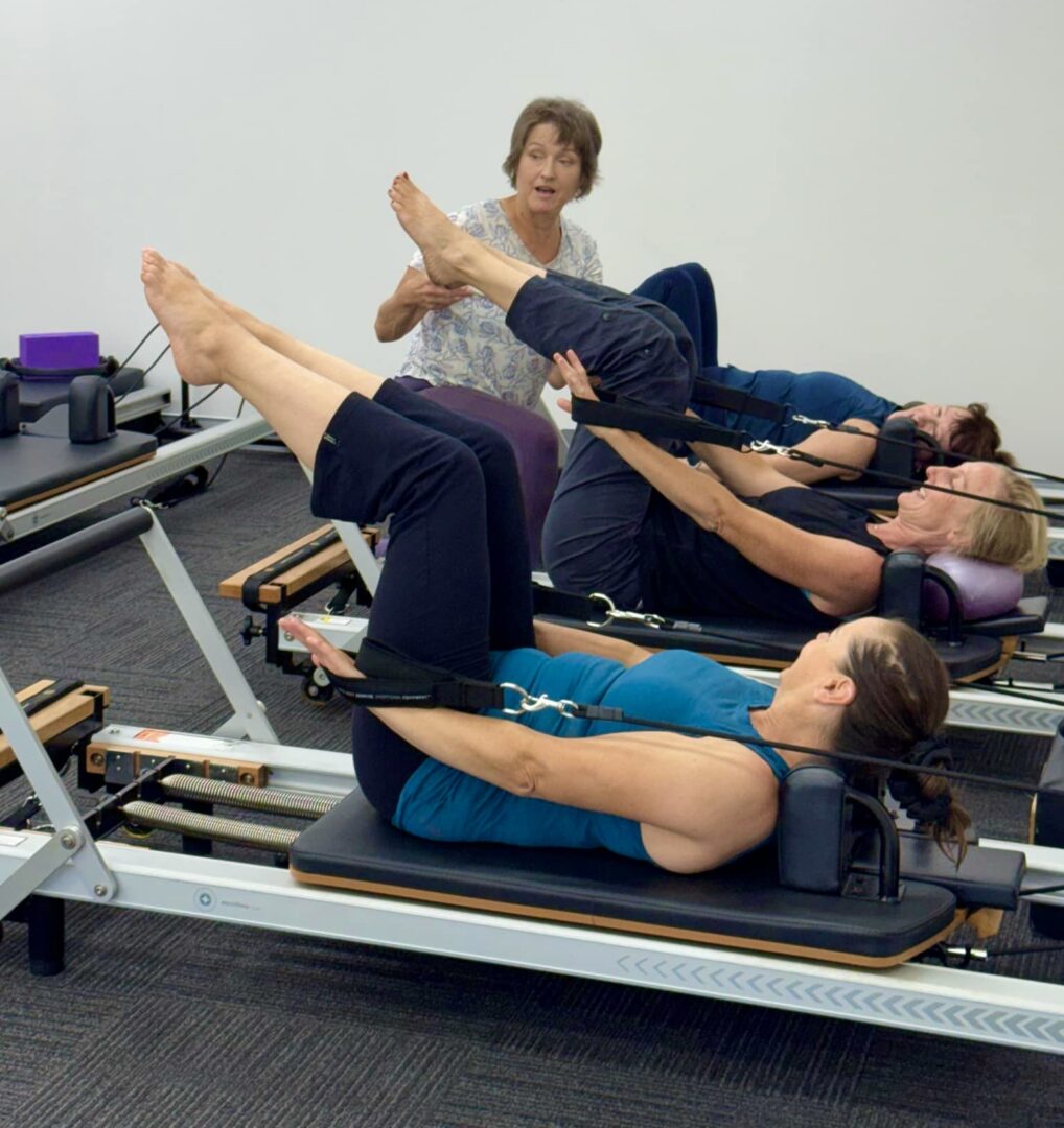 A group of people are doing exercises on the rowing machine.