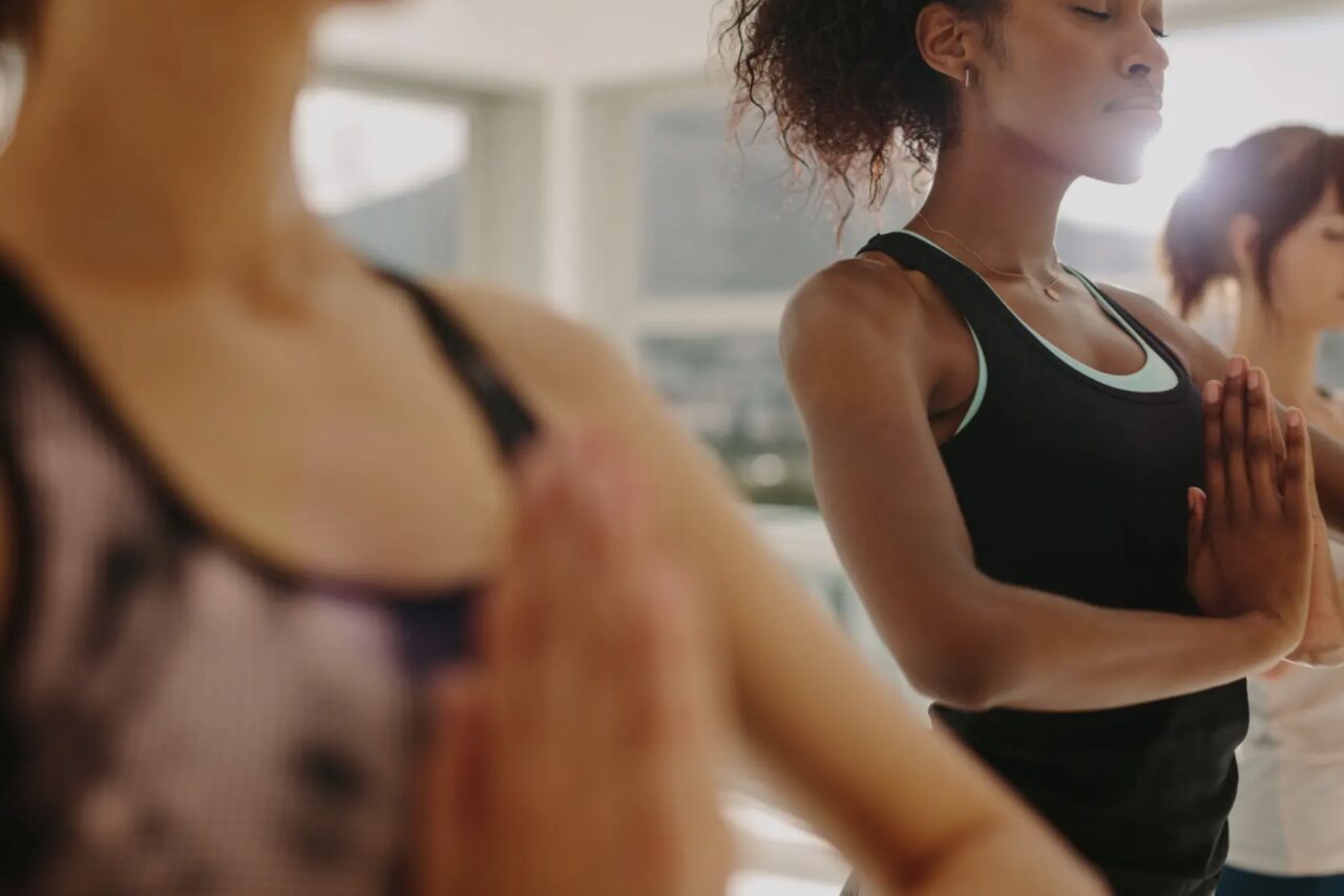 Two women are doing yoga in a room.