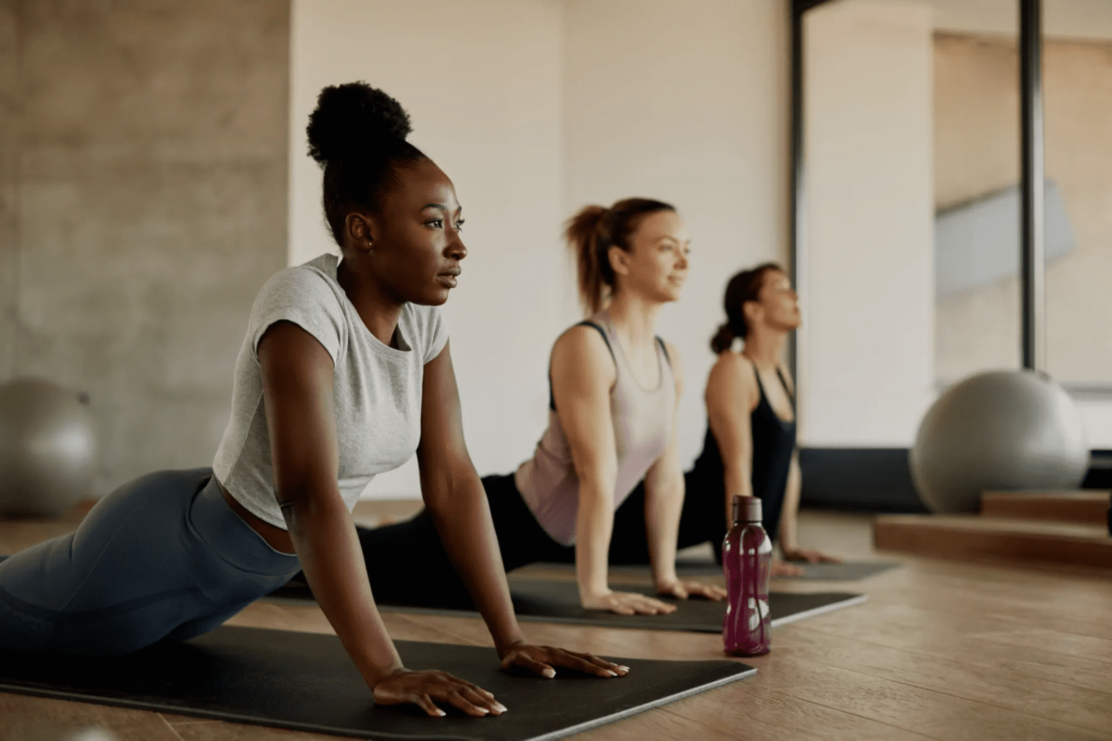 A group of women doing yoga on mats.