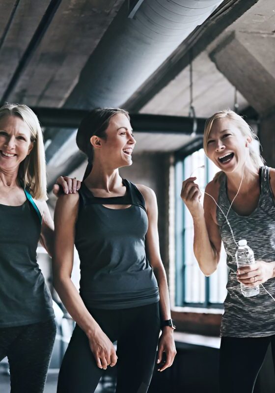 New Project Three women are standing in a gym with water.